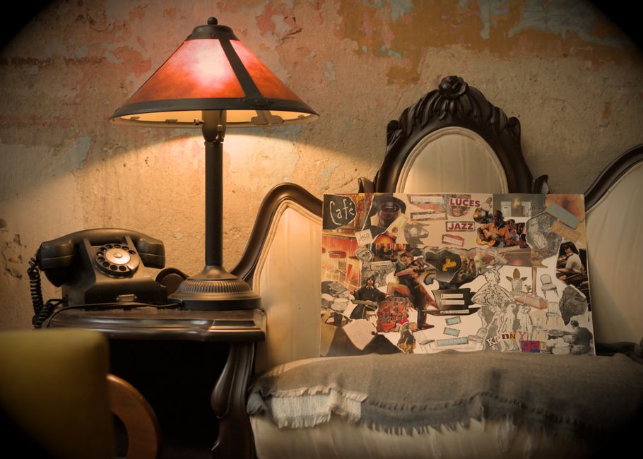 Cozy vintage scene with an antique lamp, collage art, and classic telephone for a nostalgic feel.